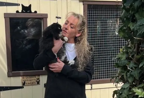 Keeley with one of her feline guests outside the cattery